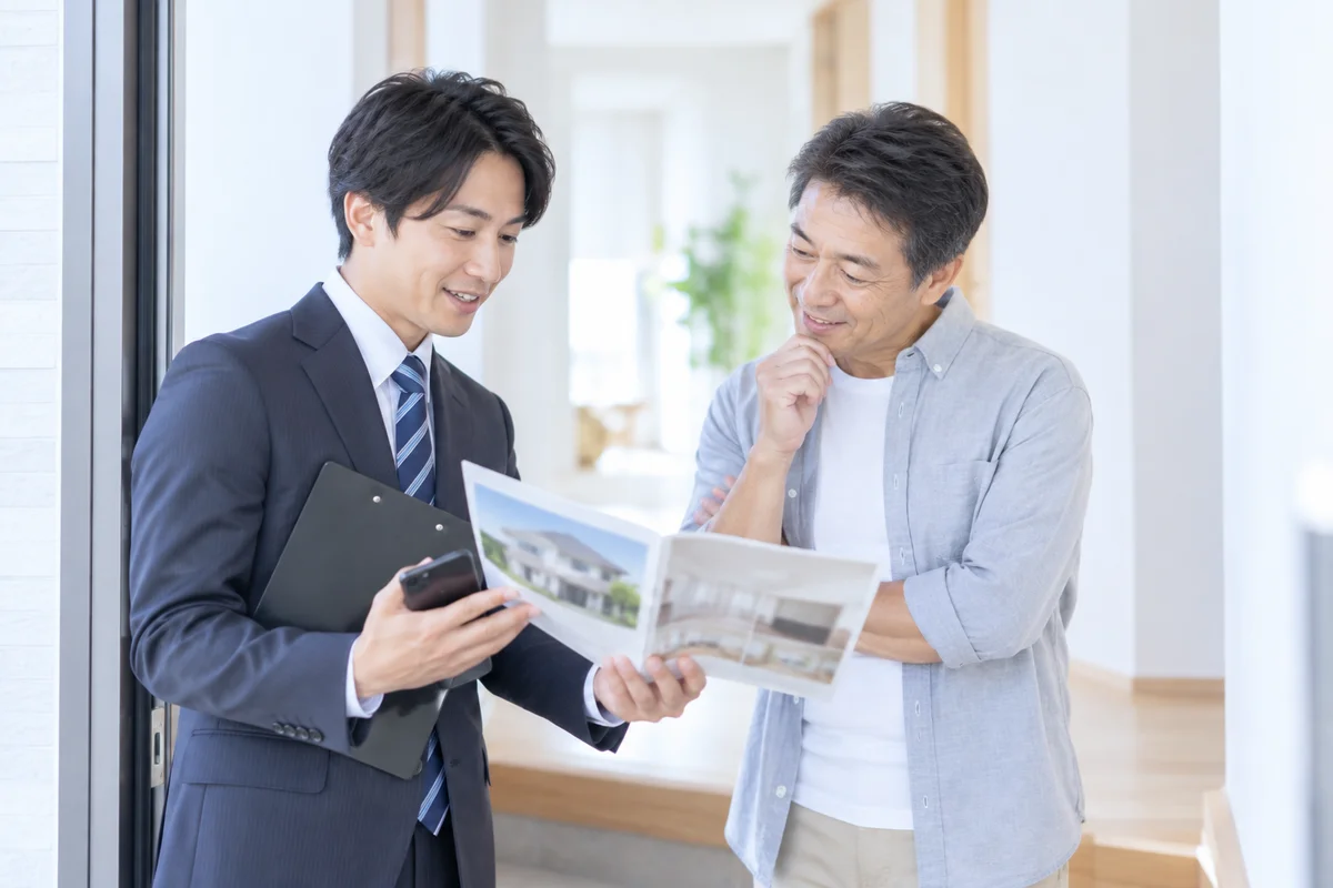 訪問先の玄関で資料を説明する営業担当
